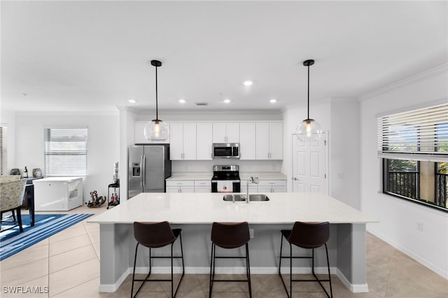 kitchen featuring stainless steel appliances, an island with sink, sink, and pendant lighting