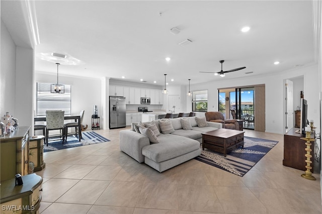 tiled living room featuring crown molding and ceiling fan with notable chandelier