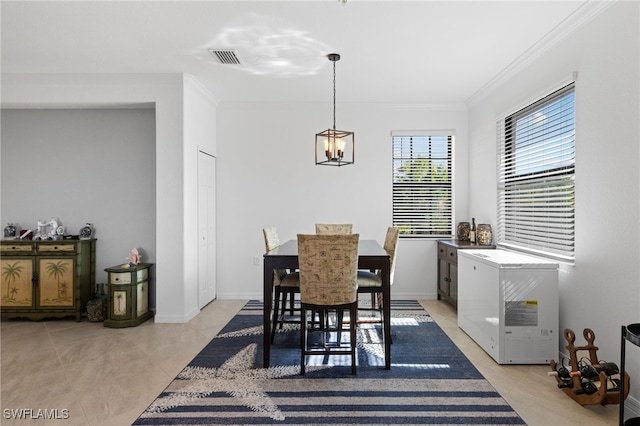 tiled dining space featuring an inviting chandelier and ornamental molding