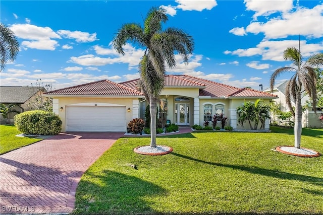 mediterranean / spanish-style house featuring a front yard and a garage