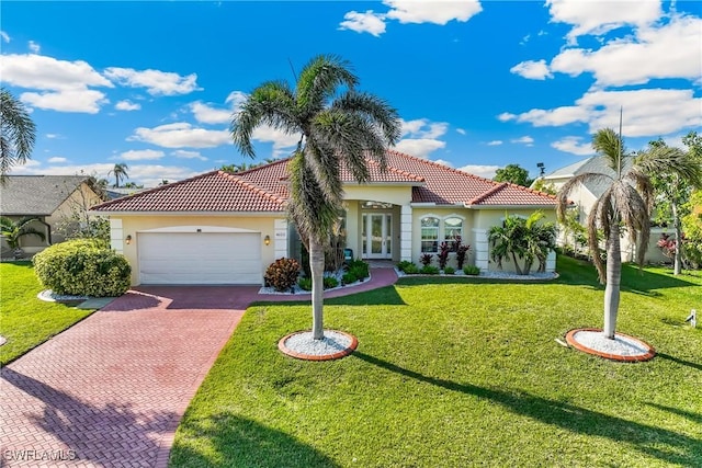 mediterranean / spanish-style home featuring a front yard and a garage