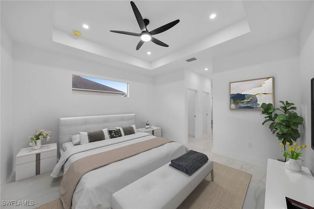 bedroom with ceiling fan and a raised ceiling