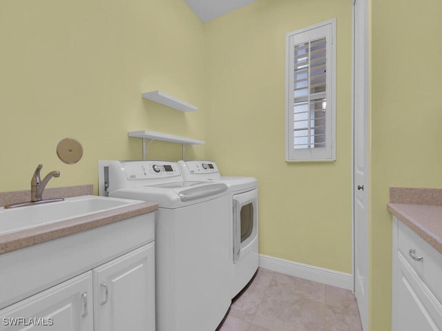 clothes washing area with cabinets, washer and dryer, and sink