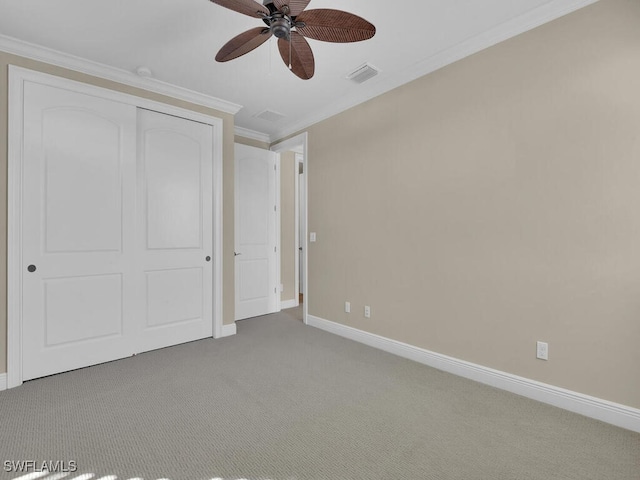 unfurnished bedroom featuring crown molding, carpet floors, ceiling fan, and a closet