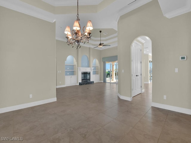 unfurnished living room featuring ceiling fan with notable chandelier, ornamental molding, a raised ceiling, tile patterned floors, and built in shelves