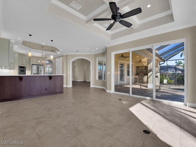 unfurnished living room with light tile patterned flooring, coffered ceiling, ornamental molding, a raised ceiling, and ceiling fan