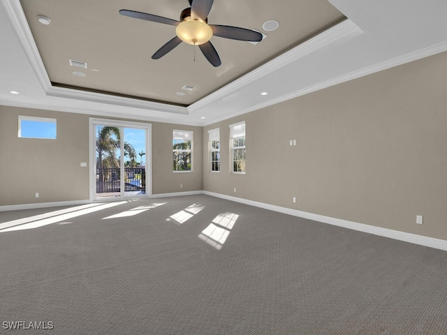 carpeted spare room featuring crown molding, a tray ceiling, and ceiling fan