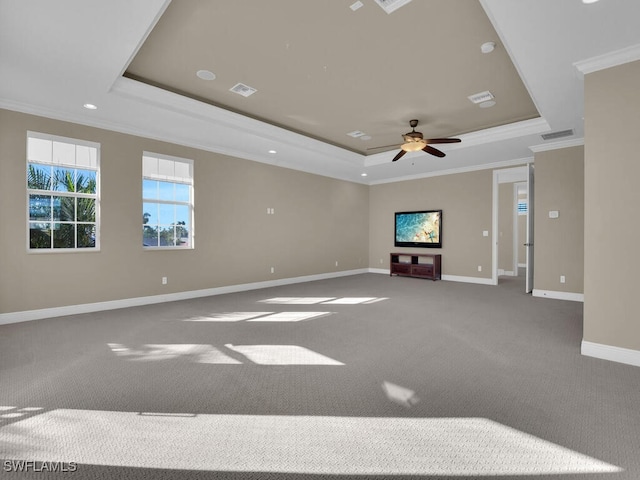 unfurnished living room featuring a tray ceiling, ornamental molding, ceiling fan, and carpet