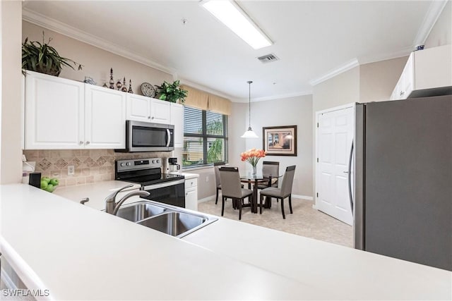 kitchen with pendant lighting, sink, crown molding, stainless steel appliances, and white cabinets