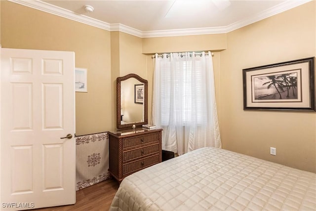 bedroom featuring ceiling fan, ornamental molding, and hardwood / wood-style flooring