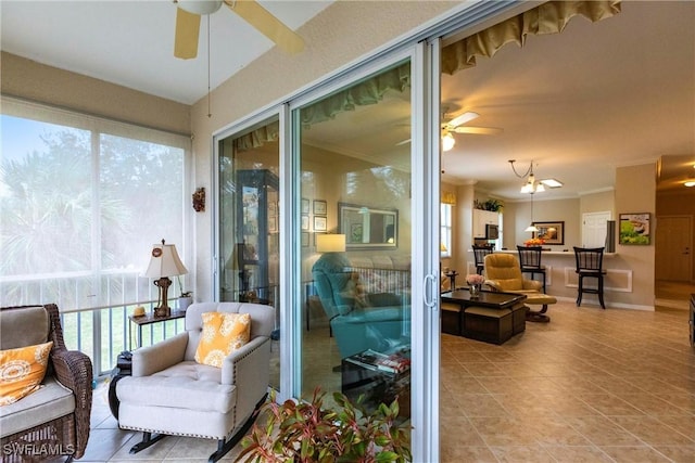 sunroom featuring ceiling fan and plenty of natural light