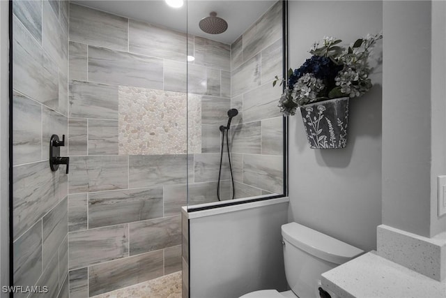 bathroom with tiled shower and toilet