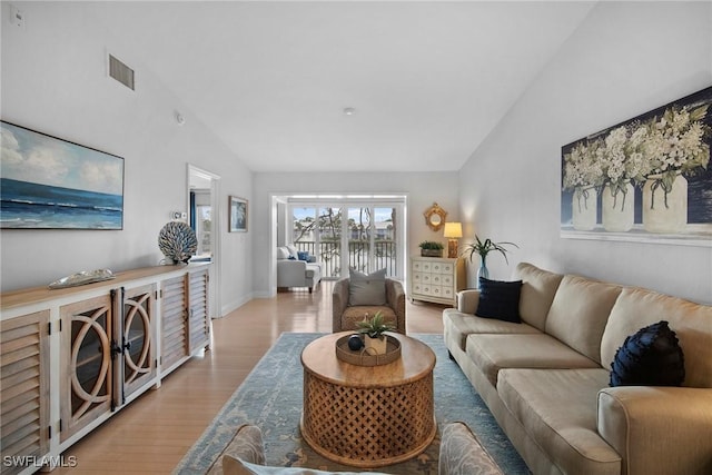 living room featuring high vaulted ceiling and light wood-type flooring