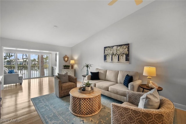 living room with a water view, ceiling fan, high vaulted ceiling, and light hardwood / wood-style floors