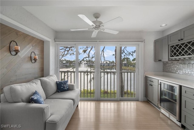 interior space featuring wine cooler, a wealth of natural light, bar area, and a water view