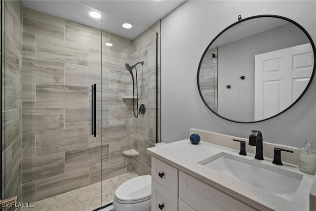 bathroom featuring vanity, toilet, and a shower with door