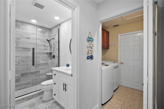 bathroom featuring washer and clothes dryer, tile patterned flooring, vanity, an enclosed shower, and toilet