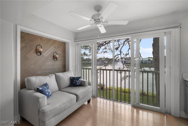 sunroom / solarium with a water view and ceiling fan