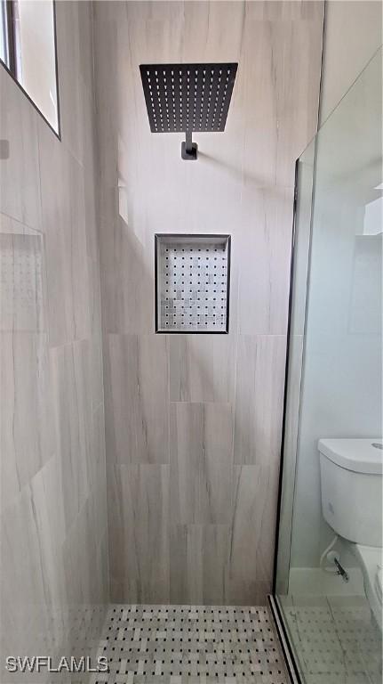 bathroom featuring toilet and tiled shower