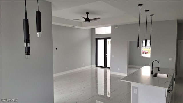 kitchen with decorative light fixtures, light stone countertops, sink, and plenty of natural light