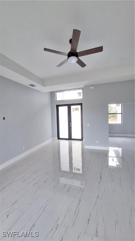 unfurnished room with ceiling fan and french doors