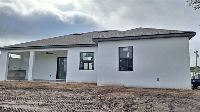 rear view of property with ceiling fan