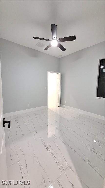 unfurnished room featuring marble finish floor, visible vents, ceiling fan, and baseboards