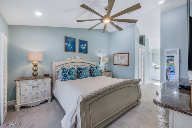 carpeted bedroom featuring ceiling fan, ensuite bathroom, and high vaulted ceiling