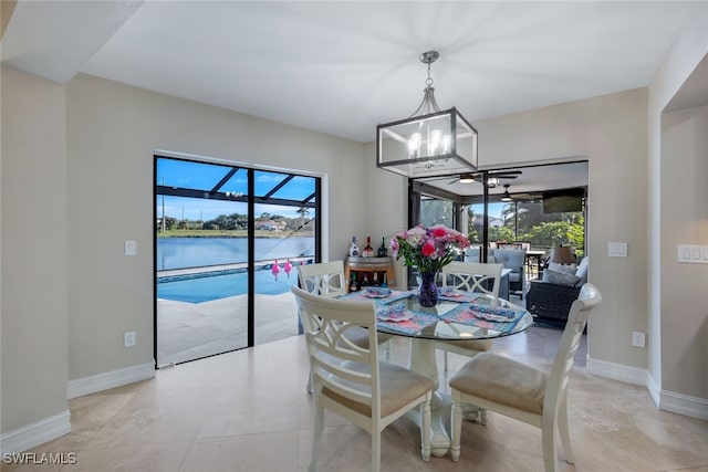 dining room featuring a water view, plenty of natural light, and a notable chandelier