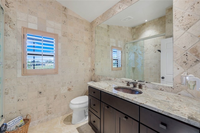 bathroom featuring tile walls, vanity, tile patterned floors, toilet, and walk in shower