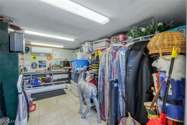 walk in closet with a wall mounted air conditioner and light tile patterned floors