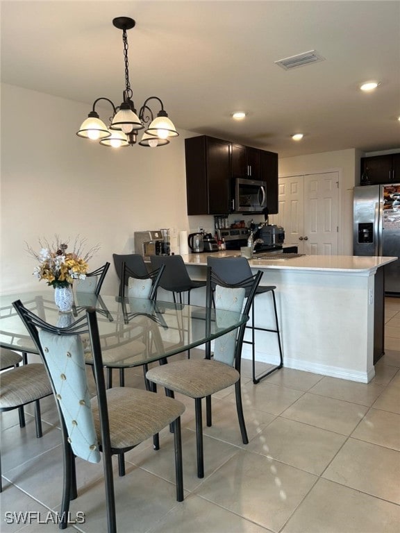 tiled dining room with a notable chandelier