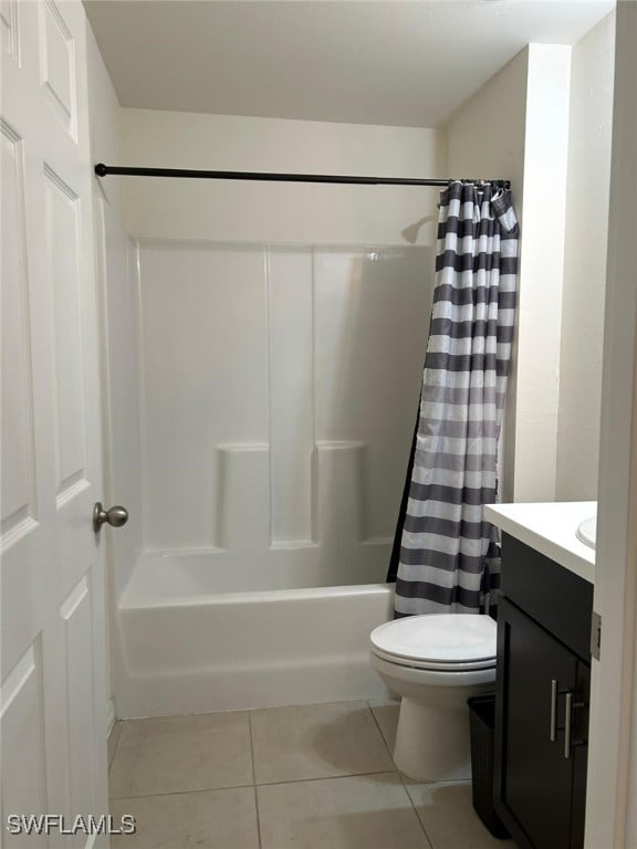 full bathroom featuring toilet, vanity, tile patterned floors, and shower / bathtub combination with curtain