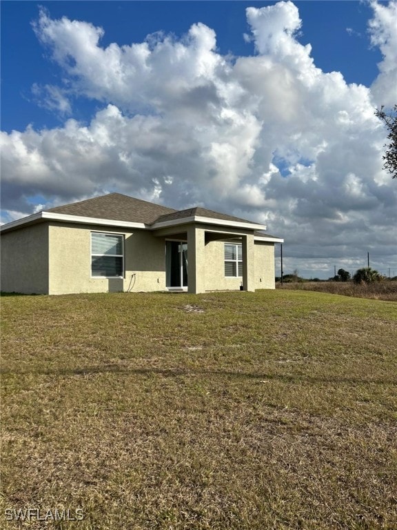 back of property featuring a lawn