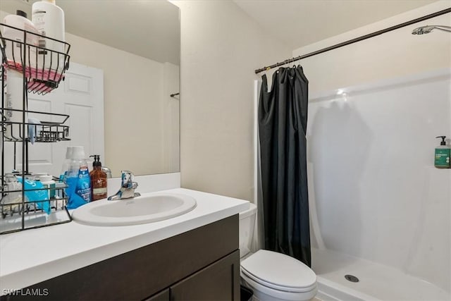 bathroom featuring vanity, curtained shower, and toilet