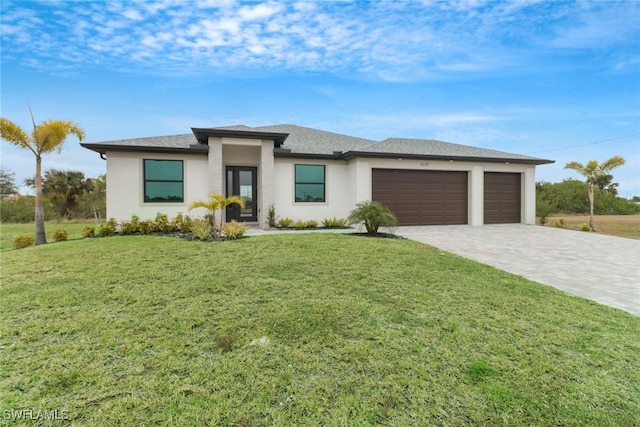 prairie-style home featuring a garage and a front lawn