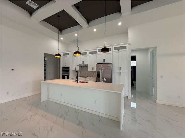 kitchen featuring a large island, stainless steel appliances, backsplash, decorative light fixtures, and sink