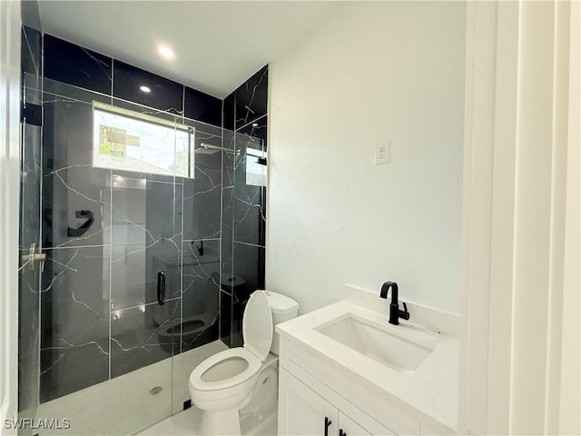 bathroom with toilet, vanity, and a shower with door