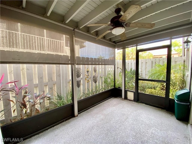 unfurnished sunroom featuring vaulted ceiling with beams and ceiling fan