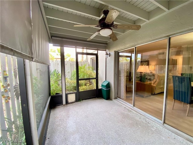 unfurnished sunroom with beamed ceiling and ceiling fan