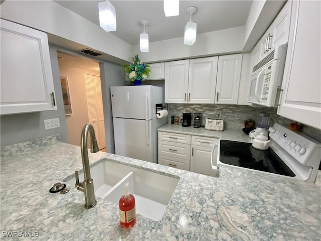 kitchen featuring pendant lighting, white cabinetry, sink, light stone counters, and white appliances