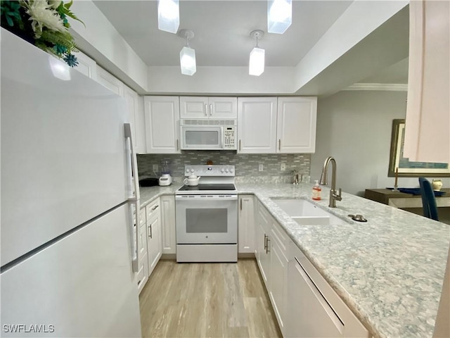 kitchen with hanging light fixtures, white cabinetry, sink, and white appliances