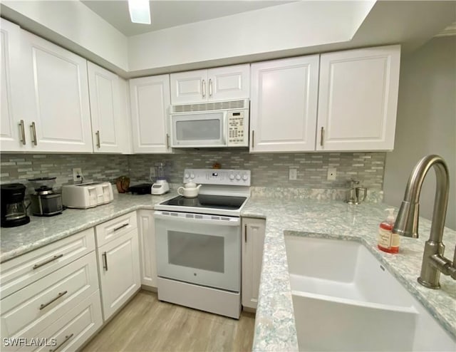 kitchen featuring white cabinetry, sink, white appliances, and decorative backsplash