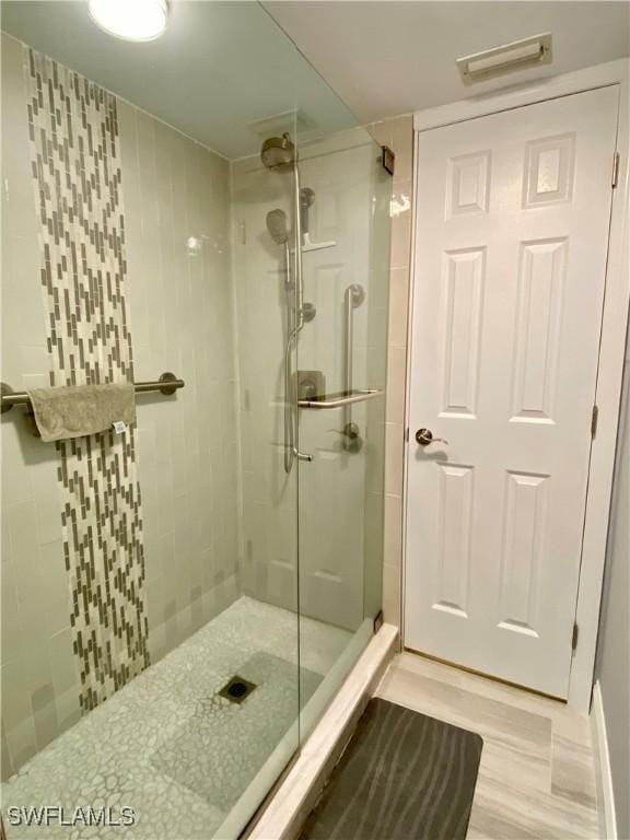 bathroom with walk in shower and hardwood / wood-style floors