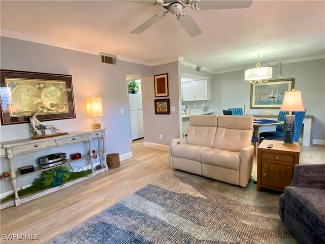 living room featuring crown molding, ceiling fan, and light wood-type flooring