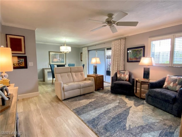 living room with hardwood / wood-style floors, crown molding, and ceiling fan with notable chandelier