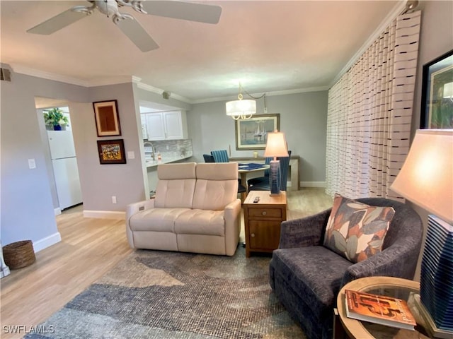 living room featuring crown molding, ceiling fan with notable chandelier, and light wood-type flooring