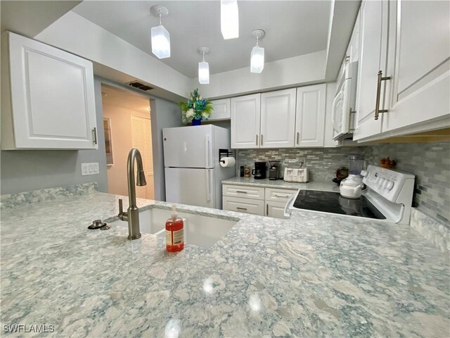 kitchen featuring pendant lighting, sink, white appliances, white cabinetry, and backsplash