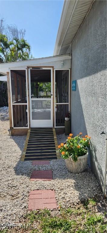 doorway to property featuring stucco siding