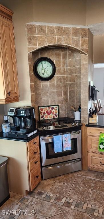 kitchen with dark countertops, stainless steel range with electric stovetop, and brown cabinetry